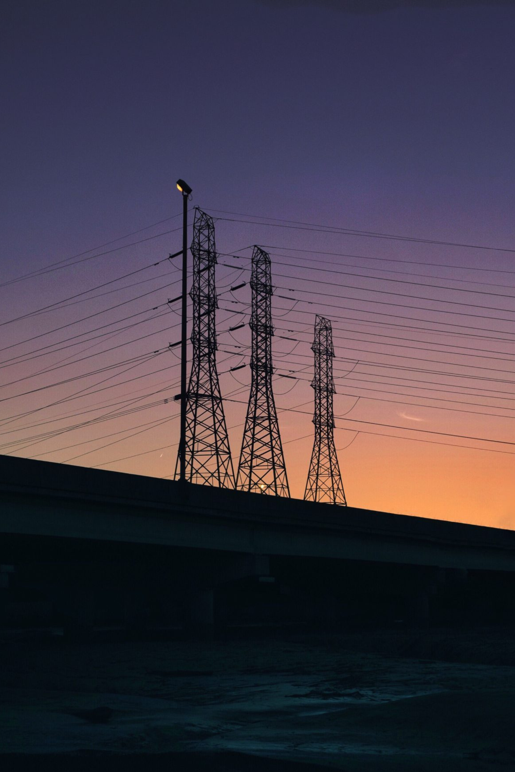 silhouette electricity pylons against sky sunset
